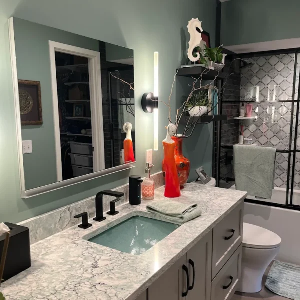 Modern bathroom remodeling with custom vanity, quartz countertop, glass vessel sink, matte black fixtures, decorative mirror, and tiled walk-in shower by Next Level Remodeling MN.