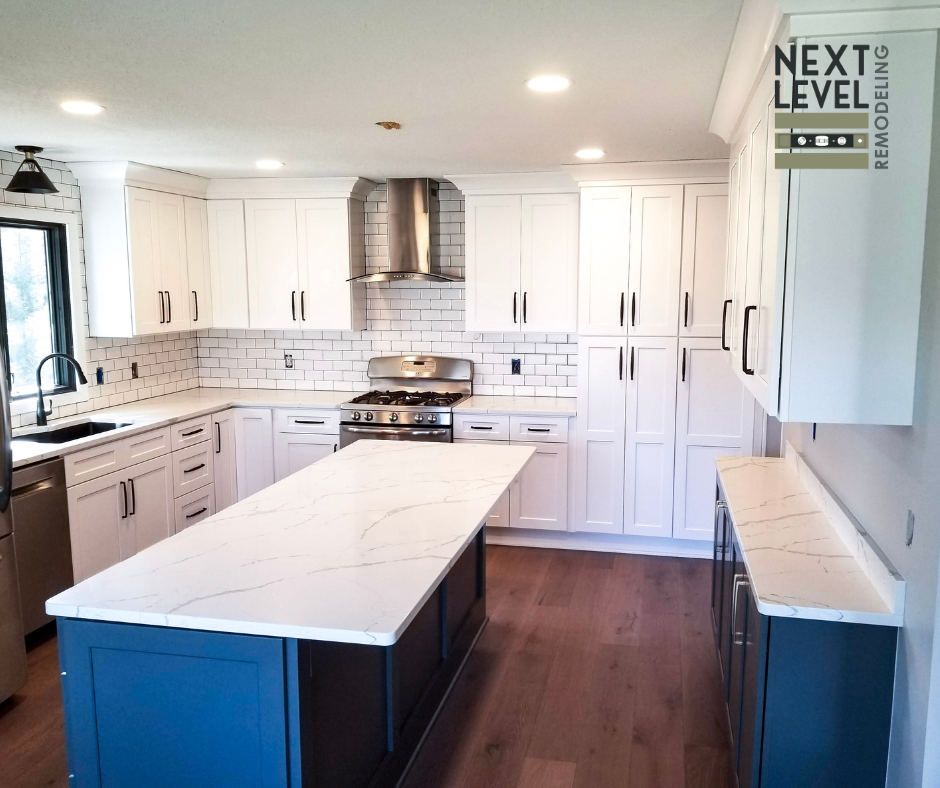 Modern kitchen remodeling with white shaker cabinets, quartz island countertop, subway tile backsplash, stainless steel range hood, and hardwood flooring by Next Level Remodeling MN.